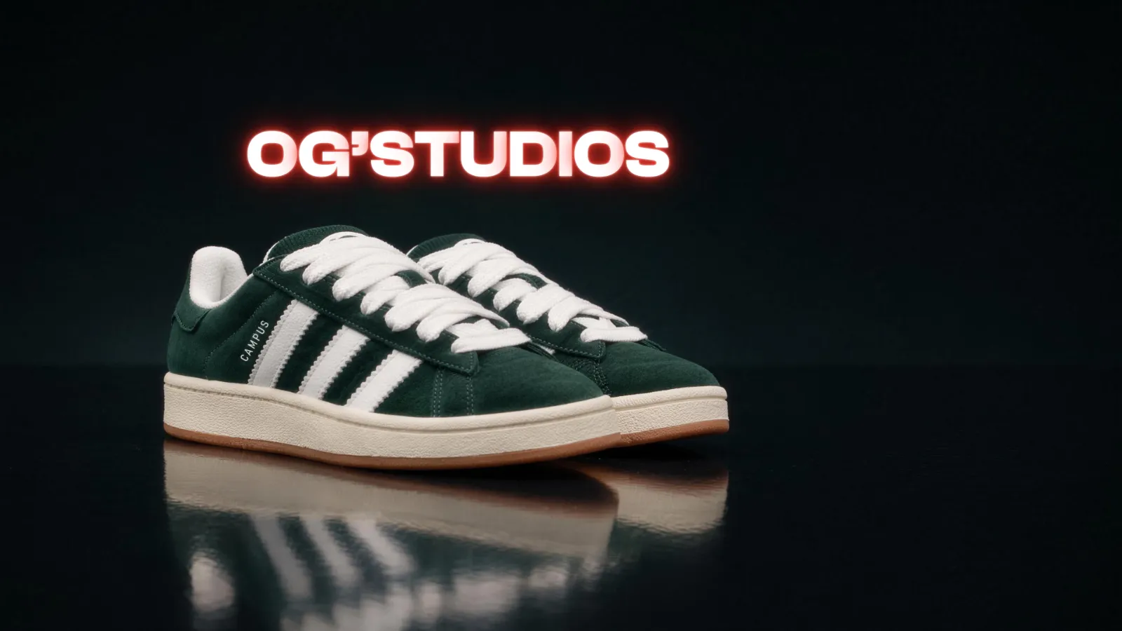 Green and white Campus sneakers on a reflective black floor under a glowing OG'STUDIOS sign